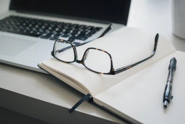 Laptop with glasses and a notebook